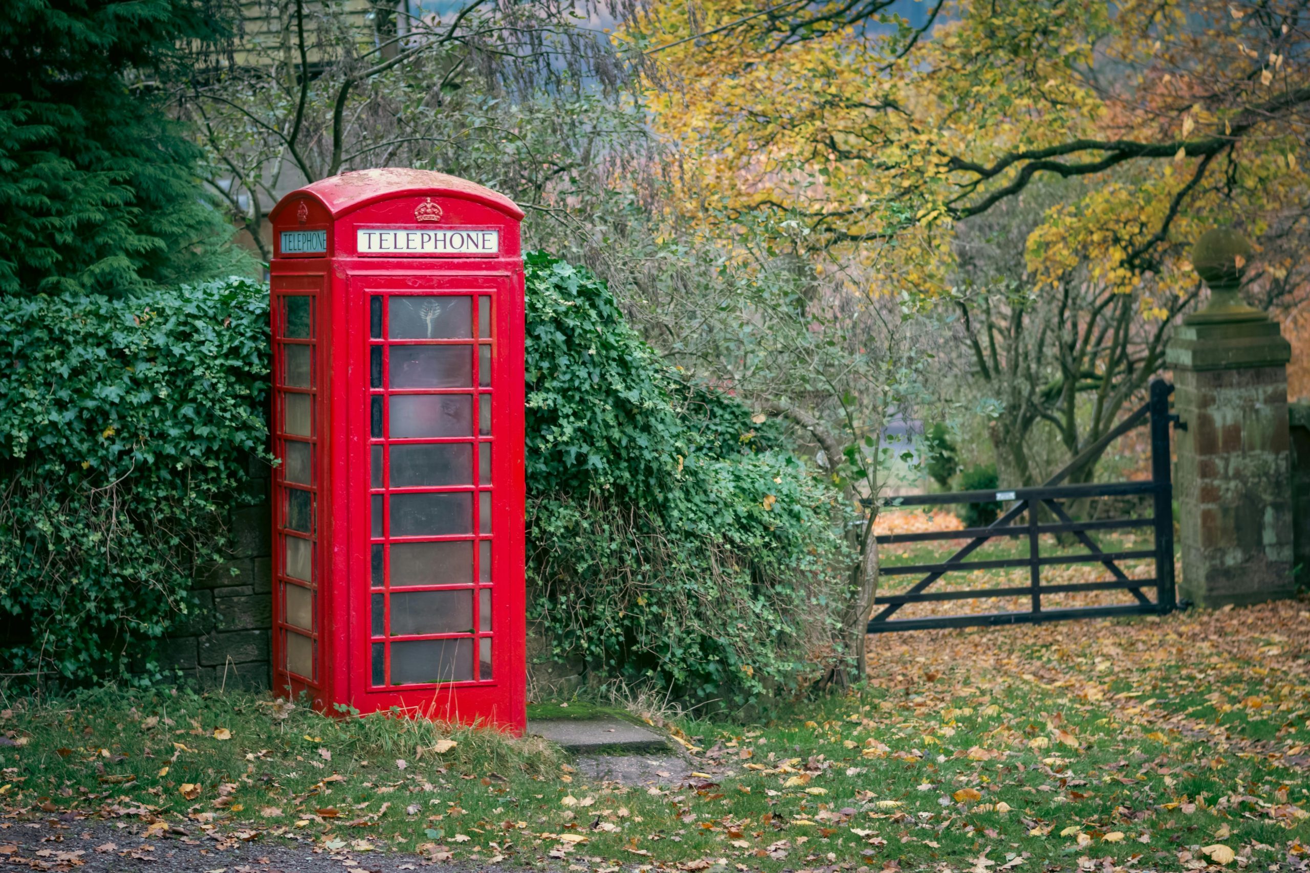 Original photo of a red phone booth in a garden