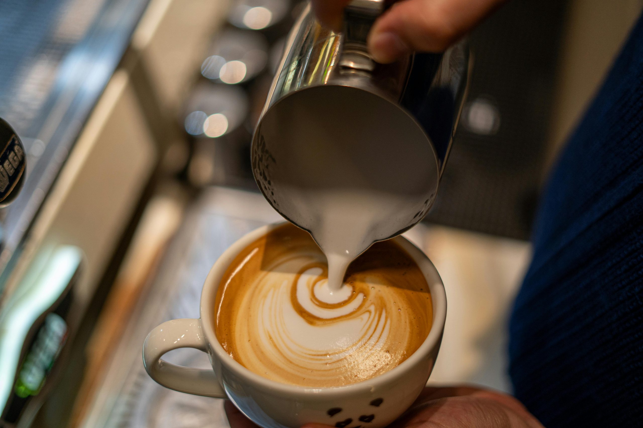 Coffee cup with milk being poured used for Moondream3 caption test